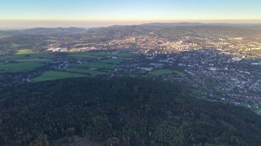 Bu çarpıcı bir hava manzarası. Güzelce sergileniyor. Canlı bir şehir manzarasının yanında yeşil alanlar yemyeşil.
