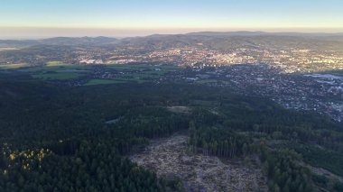 Hava manzaralı canlı bir şehir manzarası var. Şafak vakti verimli ormanlarla çevrili.
