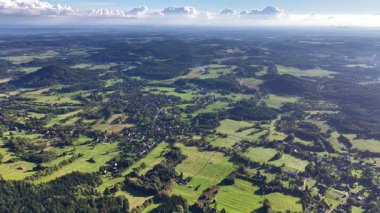Havadan çekilen güzel bir görüntü canlı yeşil tarlaları ve bulutsuz gökyüzünün altındaki küçük köyleri yakalıyor.
