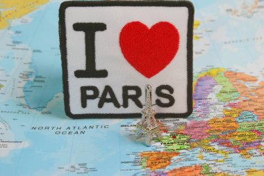 Üzerinde I Love PARIS yazan, kırmızı kalpli, nakışlı kumaş kaplama Fransa merkezli bir dünya haritasına yerleştirilmiş gümüş Eyfel Kulesi biblosuyla birleştirilmiş. Seyahat ilhamı, Paris aşkı ve el yapımı sanat birleşimi..