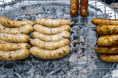 Mayalanmış domuz pirinçli sosis kömür ocağında ızgara, klasik sokak yemekleri. Kırsal dumanlı aroma ve otantik yerel tat geleneksel Tayland mutfağını ön plana çıkarıyor.