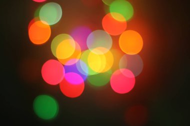 Kırmızı, yeşil, turuncu, pembe, sarı ve mor renkli koyu arkaplanlı soyut yatay görüntü. Gece festivalleri, tatiller ve yaratıcı parti tasarımları için ideal..