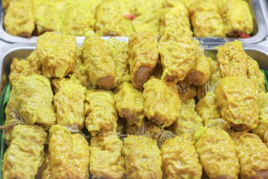 İştah açıcı Tayland usulü buğulanmış hamur tatlısı, domuz etli shumai ve altın wonton derisine sarılmış enoki mantarı. Turistler ve yerel halk tarafından sevilen popüler bir Asya Dim Sum ve sokak yemekleri lezzeti..