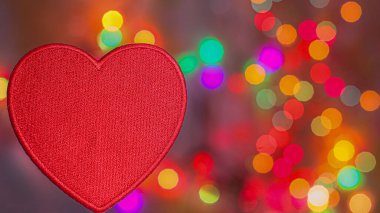 Kırmızı desenli işlemeli kalp gökkuşağı bokeh arka planda küçük parlak daireler ile. Tebrik kartı, romantik poster, sevgililer günü veya aile tatili tasarımı için uygun kopya alanı.