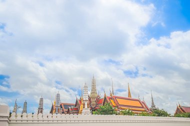 Bangkok, Tayland 'daki Zümrüt Buda Tapınağı Wat Phra Kaew' in geniş açılı görüntüsü. Süslü tapınak kuleleri ve açık mavi gökyüzü olan ikonik Büyük Saray simgesi..