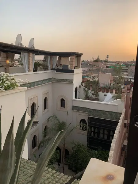Marakeş silueti günbatımında, geleneksel Riad 'ın çatısından alındı..