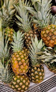 Mağazadaki tezgahta yeşil kuyruklu olgun ananaslar, mağaza satışları, reklamcılık kavramı.