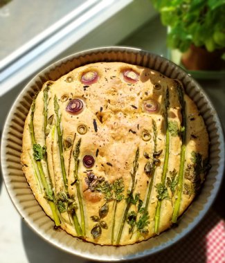 Ev yapımı Focaccia ekmeği, taze otlar ve sebzelerle. Pencerenin pervazında doğal ışık ve fesleğen olan kırsal mutfak.. 