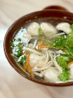 Seramik kasede balık köfteli, mantarlı ve kişniş soslu çorba.