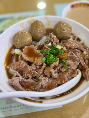 Guangzhou, China - June 3, 2025: Bowl of beef noodle soup with meatballs and scallions served at a casual Chinese eatery