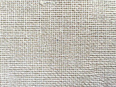 Doğal keten dokusuyla bej dokuma kumaş yüzeyinin detaylı bir görüntüsü ince liflerini ve çapraz dokuma desenini vurguluyor..