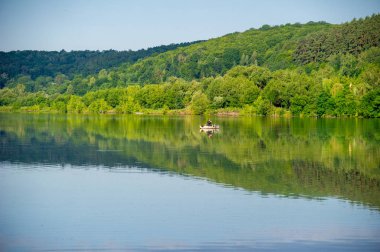 Dağlardaki gölün sularındaki ağaçların yansıması.