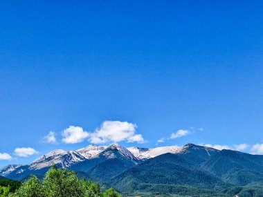 Mavi gökyüzü ve bulutlu yüksek dağ manzarası