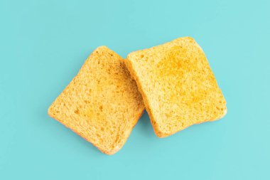 Parlak pastel mavi arka planda iki dilim kızarmış ekmek konsepti