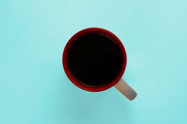 Açık mavi arka planda bir kupa kahve. Kahve molası