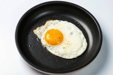 Beyaz arka planda bir tabakta kızarmış yumurta.