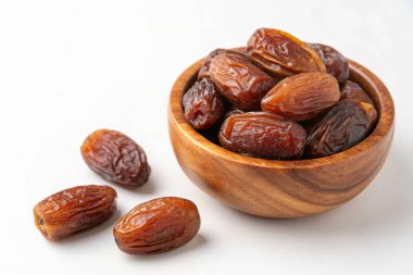 Beyaz arka planda izole edilmiş kasede kurutulmuş tarihler