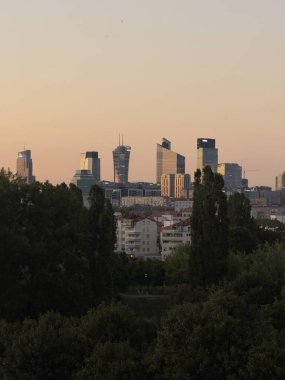 Günbatımı Şehir Gökdelenleri ve Yemyeşil Önplanı ile Gökyüzü