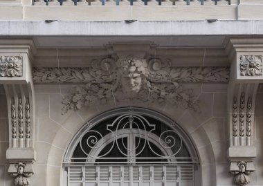 Ön cephe süslemeleri, Paris, Fransa. Paris binasının ön cephesinde gösterişli süslemeler ve dekorasyonlar. Kapılar ve pencereler, dekore edilmiş balkonlar.