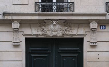 Ön cephe süslemeleri, Paris, Fransa. Paris binasının ön cephesinde gösterişli süslemeler ve dekorasyonlar. Kapılar ve pencereler, dekore edilmiş balkonlar.