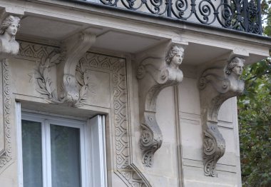 Ön cephe süslemeleri, Paris, Fransa. Paris binasının ön cephesinde gösterişli süslemeler ve dekorasyonlar. Kapılar ve pencereler, dekore edilmiş balkonlar.