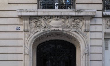 Ön cephe süslemeleri, Paris, Fransa. Paris binasının ön cephesinde gösterişli süslemeler ve dekorasyonlar. Kapılar ve pencereler, dekore edilmiş balkonlar.