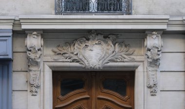 Ön cephe süslemeleri, Paris, Fransa. Paris binasının ön cephesinde gösterişli süslemeler ve dekorasyonlar. Kapılar ve pencereler, dekore edilmiş balkonlar.