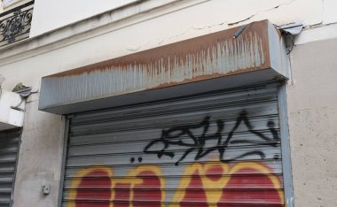 Çok eski endüstriyel makinelerde pas bozulması ve yüz yıllık mezarlığın yıpranmış kapıları (Pre Lachaise, Fransa).