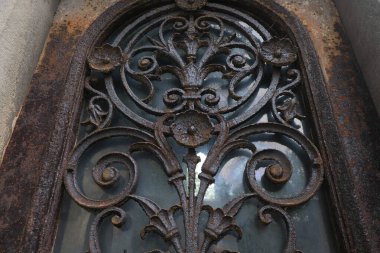 Çok eski endüstriyel makinelerde pas bozulması ve yüz yıllık mezarlığın yıpranmış kapıları (Pre Lachaise, Fransa).