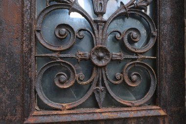 Çok eski endüstriyel makinelerde pas bozulması ve yüz yıllık mezarlığın yıpranmış kapıları (Pre Lachaise, Fransa).