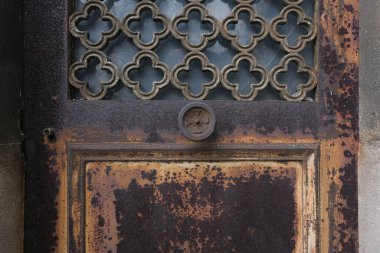 Çok eski endüstriyel makinelerde pas bozulması ve yüz yıllık mezarlığın yıpranmış kapıları (Pre Lachaise, Fransa).