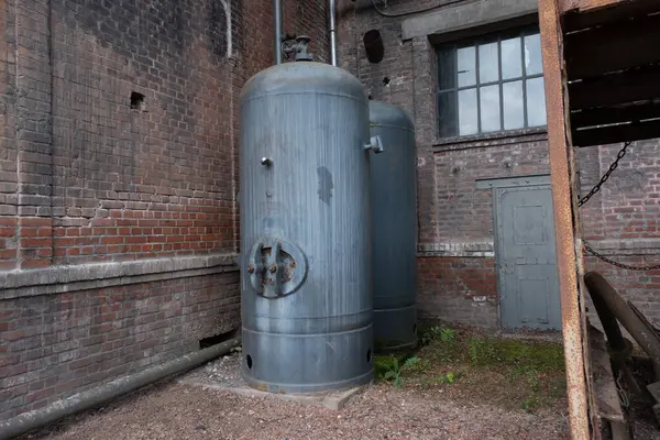 Çok eski endüstriyel makinelerde pas bozulması ve yüz yıllık mezarlığın yıpranmış kapıları (Pre Lachaise, Fransa).