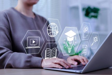 Çevrimiçi eğitim ve e-öğrenme kavramı. Bir kişi çevrimiçi eğitim, öğrenme, bilgi paylaşımı, eğitim araçları, eğitim, İnternet 'te webinar, dijital kursları temsil eden bir dizüstü bilgisayar kullanır,