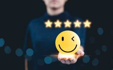 Müşteri memnuniyet değerlendirmesi anket konsepti. Müşteri tecrübesi, müşteri memnuniyeti için en iyi hizmet derecesi gülümseme ifadesi gösteren beş yıldızlı bir müşterinin elinde..