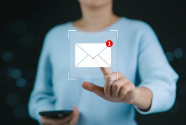 Yeni e-posta etkileşim konsepti. Yeni bir e-posta bildirim sembolü gösteren dijital bir arayüzle etkileşime giren bir kadın, çevrimiçi iletişim için bir kavram. E-posta pazarlama, posta güvenliği,