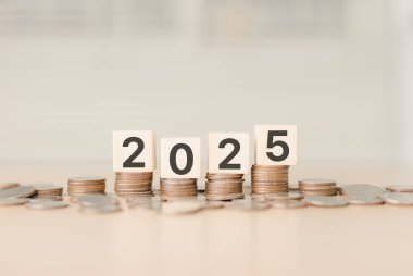 Finansal trendler ve 2025 yılı ekonomisi. 2025 yılı ahşap bloklar madeni para yığınları, mali büyüme, ekonomik eğilim, yatırım fırsatları, gelecekteki finansal planlama, iş büyümesi,