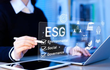 ESG çevresel sosyal yönetim iş konsepti. Diz üstü bilgisayarı ESG kullanan iş kadını, sürdürülebilir iş uygulamalarını, etik yatırımları ve kurumsal sorumluluğu sembolize ediyor.