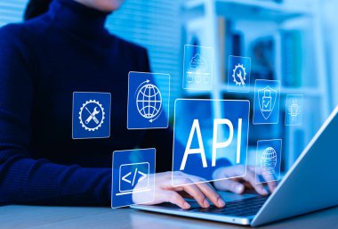 API Uygulama Programlama Arayüz Kavramı. Bir kişi, API geliştirme, güvenlik ve bulut hesaplama teknolojisini temsil eden dijital simgelerle dizüstü bilgisayara yazar. ağ uygulama yazılım aracı