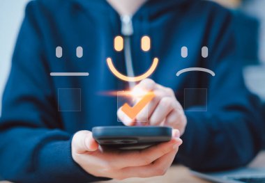 Müşteri memnuniyet değerlendirmesi anket konsepti. Müşteri memnuniyeti seviyelerini temsil eden sanal ikonlar ile etkileşime giren bir insan, buna mutlu, nötr ve üzgün yüzler ve geri bildirim de dahil. sıralama,