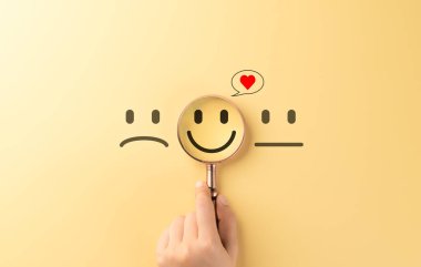 Akıl Sağlığı ve Pozitif Refah Konsepti. Büyüteç mutlu, gülen bir yüze odaklanır, ruh sağlığı, pozitiflik ve duygusal refahı sembolize eder. Müşteri memnuniyeti,