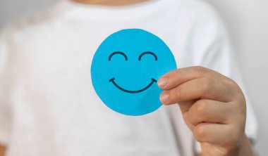 Çocuk elinde kağıt kesiği sembolü, gülümseme, mutluluk, rahatlama, memnuniyet anketi, müşteri hizmetleri, olumlu, iyi, sağlıklı çocuk, sağlık çocuğu, hastane, dünya akıl sağlığı günü konsepti