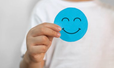Çocuk elinde kağıt kesiği sembolü, gülümseme, mutluluk, rahatlama, memnuniyet anketi, müşteri hizmetleri, olumlu, iyi, sağlıklı çocuk, sağlık çocuğu, hastane, dünya akıl sağlığı günü konsepti