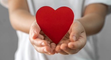 Çocuk elinde kırmızı kalp kağıdı kesiği, sağlık ve sağlık, aşk, kalp krizi, dünya kalp krizi, kardiyovasküler hastalık, doktor, aile, bağış, sigorta ve hastane konsepti