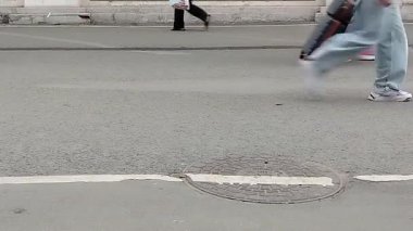 Asfaltta yürüyen insanların ayakları, bavulları olan bir sürü insan..