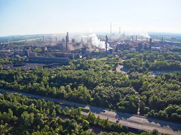 Çek Cumhuriyeti 'nin Ostrava kentindeki büyük çelik fabrikasının insansız hava aracı görüntüsü. Bu tesis gibi çok duman ve tozla birlikte bölgedeki ana hava kirleticilerden biri. Ufuktaki Beskydy Dağları.