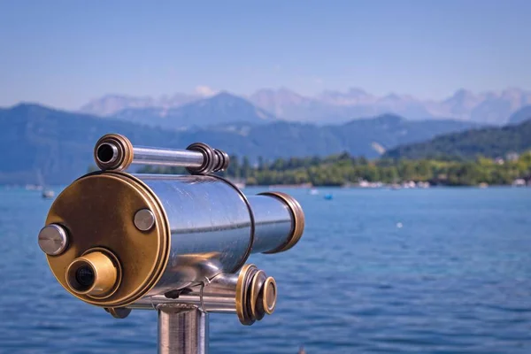 Old antique public telescope for viewing the Alps on the shore of a lake in Lucern, Swtizerland