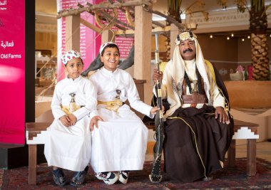 Buraydah, Suudi Arabistan, 4 Ağustos 2023: Geleneksel giyinmiş iki çocuklu Suudi bir adamın portresi