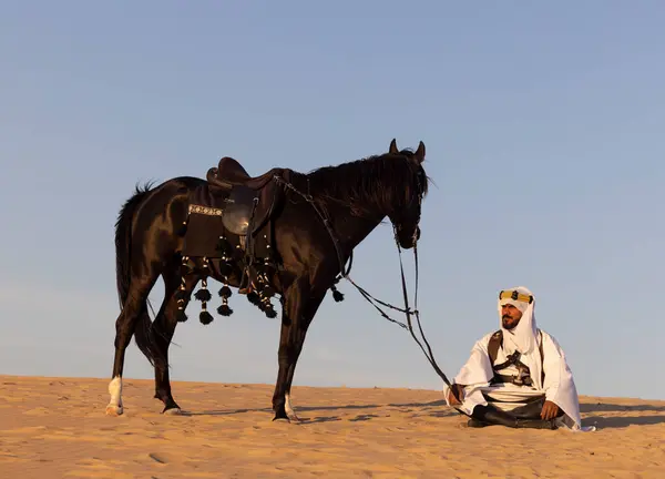 Muž Tradičním Saúdskoarabském Oblečení Poušti Černým Hřebcem Loveckými Psy — Stock fotografie