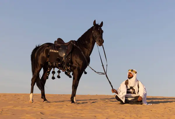 Muž Tradičním Saúdskoarabském Oblečení Poušti Černým Hřebcem Loveckými Psy — Stock fotografie
