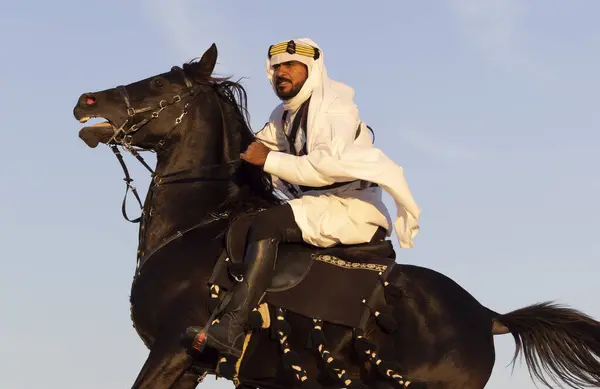 披着传统沙特阿拉伯服装的男人 身披黑马的沙漠 — 图库照片